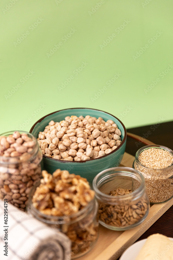 bowl full of chickpeas on wooden table with green background. Top view.