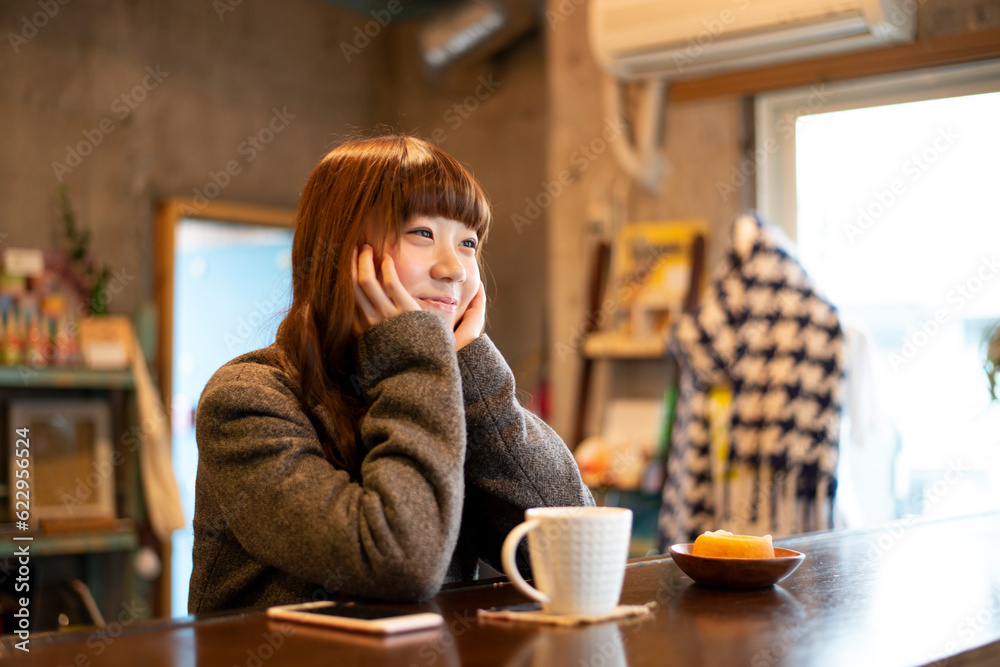 カフェのカウンターで頬杖をついている女性 カフェのカウンターで頬杖をついている女性