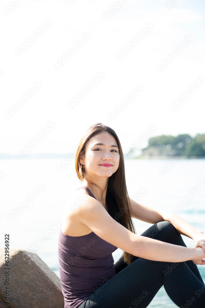 水辺に座ってこちらを見ている女性 水辺に座ってこちらを見ている女性