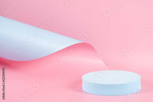 Abstract trendy composition with empty round podium platform for product or cosmetics presentation on pastel pink and light blue background. Trendy modern curved shaped lines. Front view