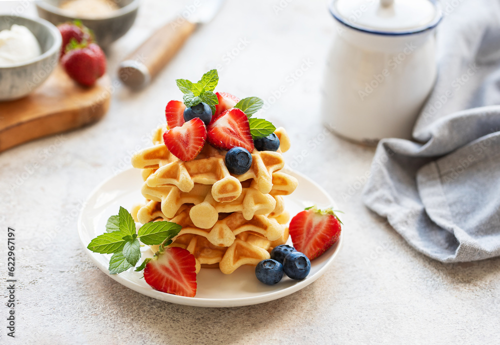 Freshly baked waffles with strawberries and blueberries Freshly baked waffles with strawberries and blueberries