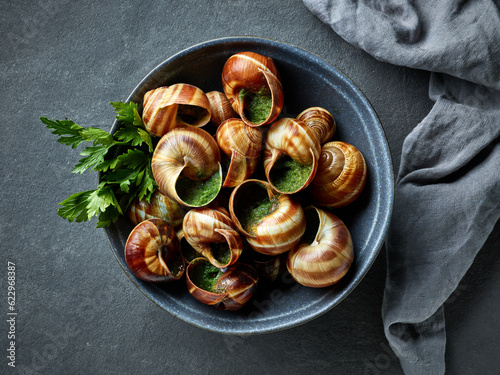 bowl of escargot snail filled with garlic and parsley butter photo