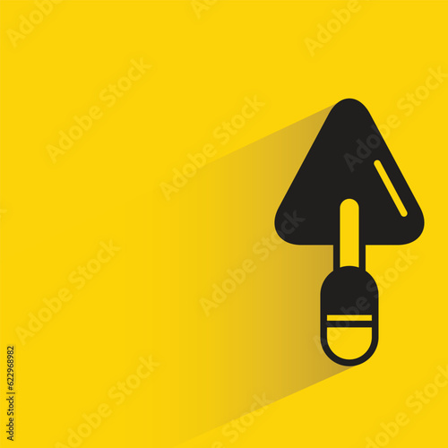 trowel with shadow on yellow background