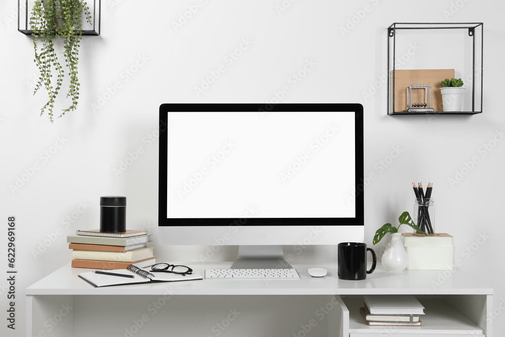 Cozy workspace with computer and stationery on wooden desk at home Cozy workspace with computer and stationery on wooden desk at home
