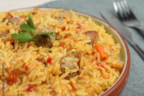 Delicious pilaf with meat served on grey tablecloth, closeup