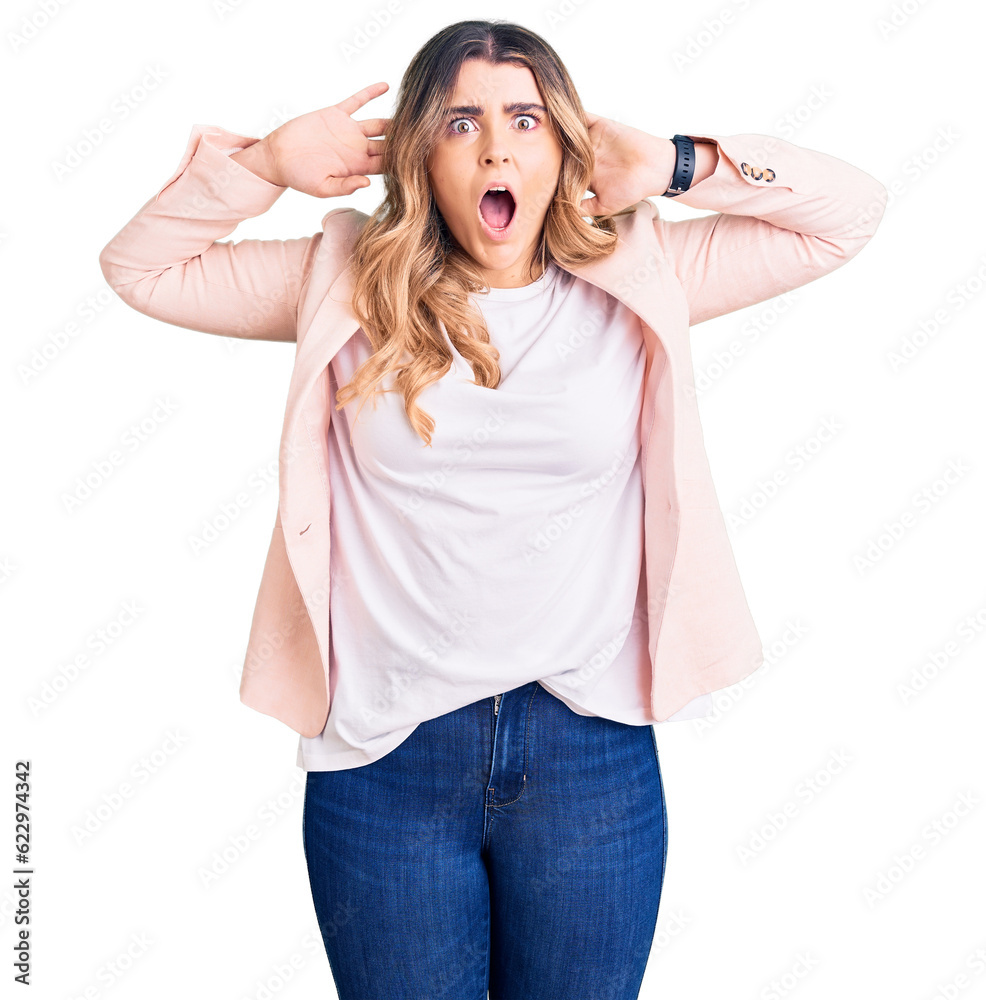 Young caucasian woman wearing business clothes crazy and scared with hands on head, afraid and surprised of shock with open mouth Young caucasian woman wearing business clothes crazy and scared with hands on head, afraid and surprised of shock with open mouth