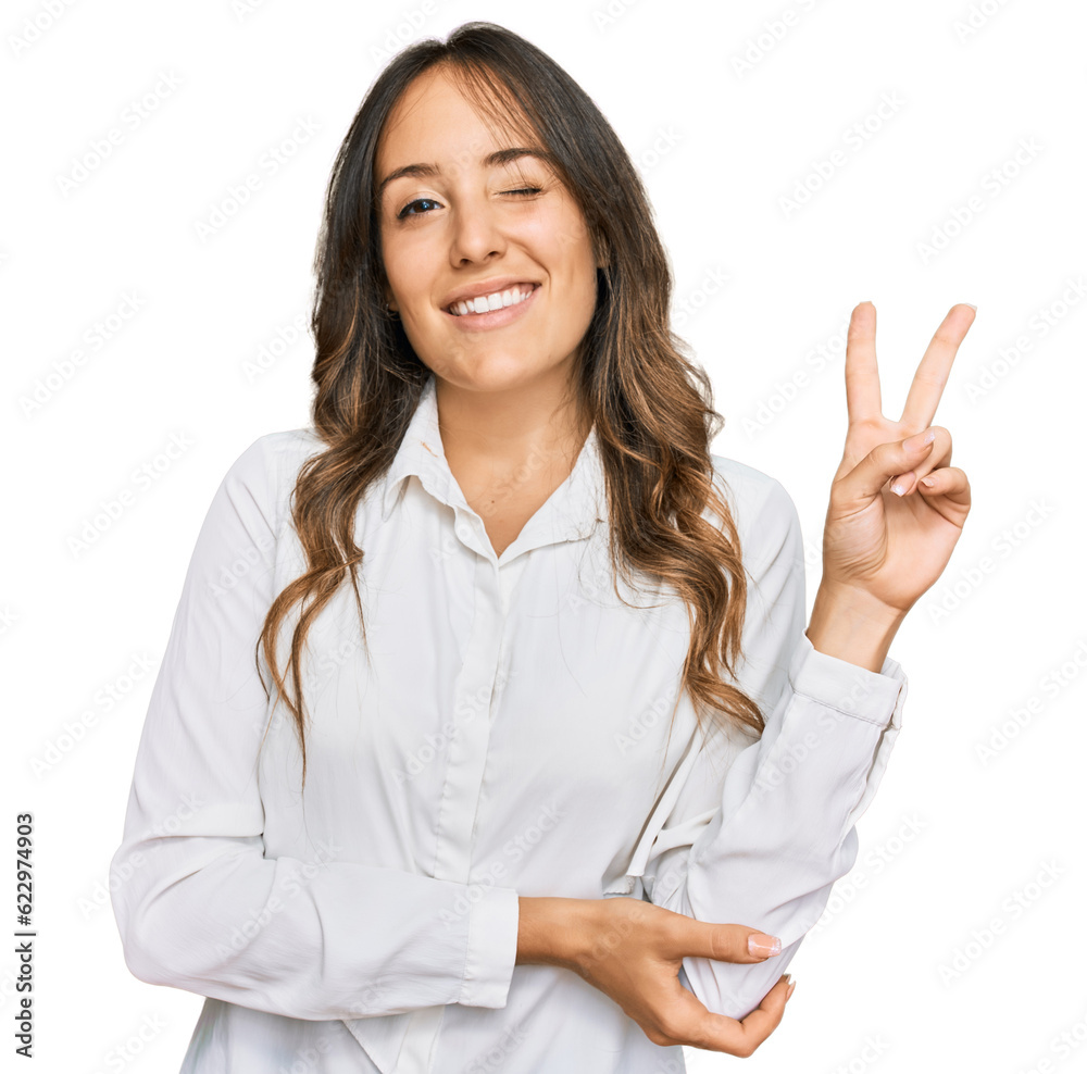 Young brunette woman wearing casual clothes smiling with happy face winking at the camera doing victory sign. number two. Young brunette woman wearing casual clothes smiling with happy face winking at the camera doing victory sign. number two.