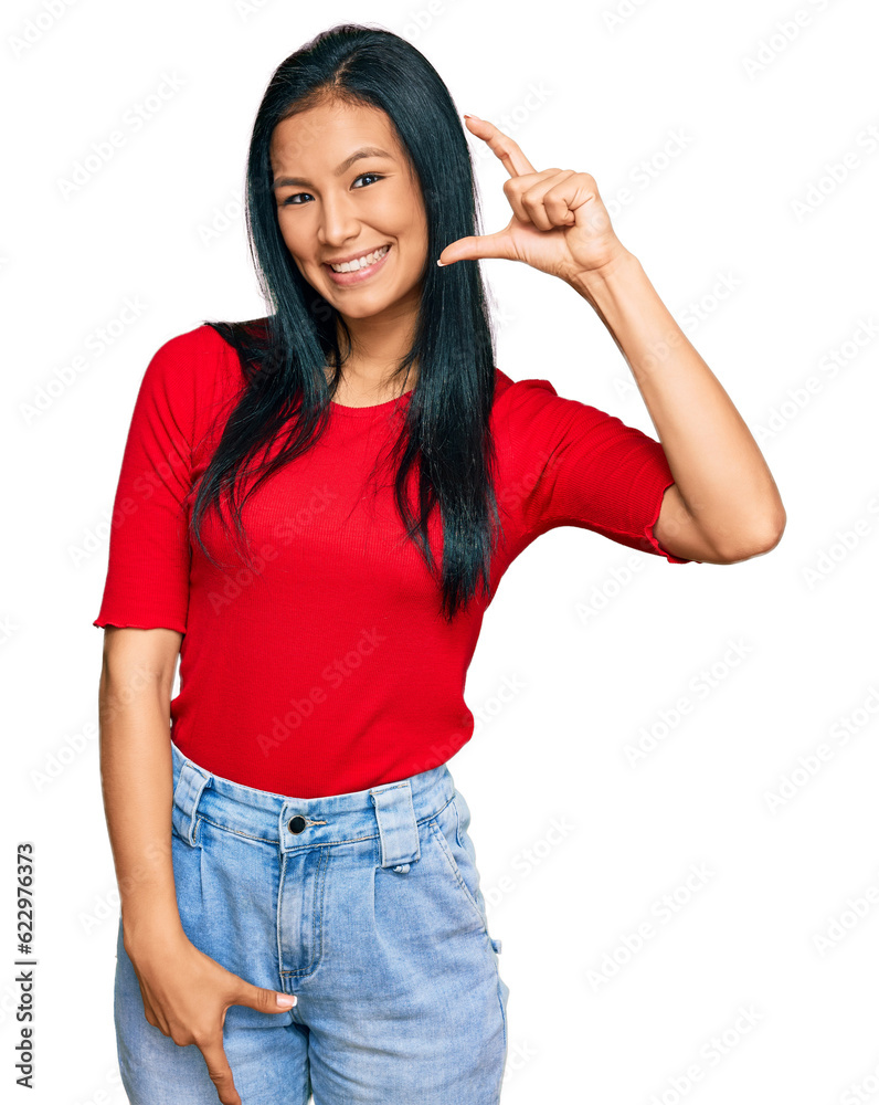 Beautiful hispanic woman wearing casual clothes smiling and confident gesturing with hand doing small size sign with fingers looking and the camera. measure concept. Beautiful hispanic woman wearing casual clothes smiling and confident gesturing with hand doing small size sign with fingers looking and the camera. measure concept.