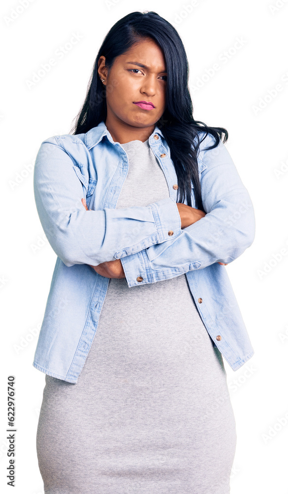 Hispanic woman with long hair wearing casual denim jacket skeptic and nervous, disapproving expression on face with crossed arms. negative person.