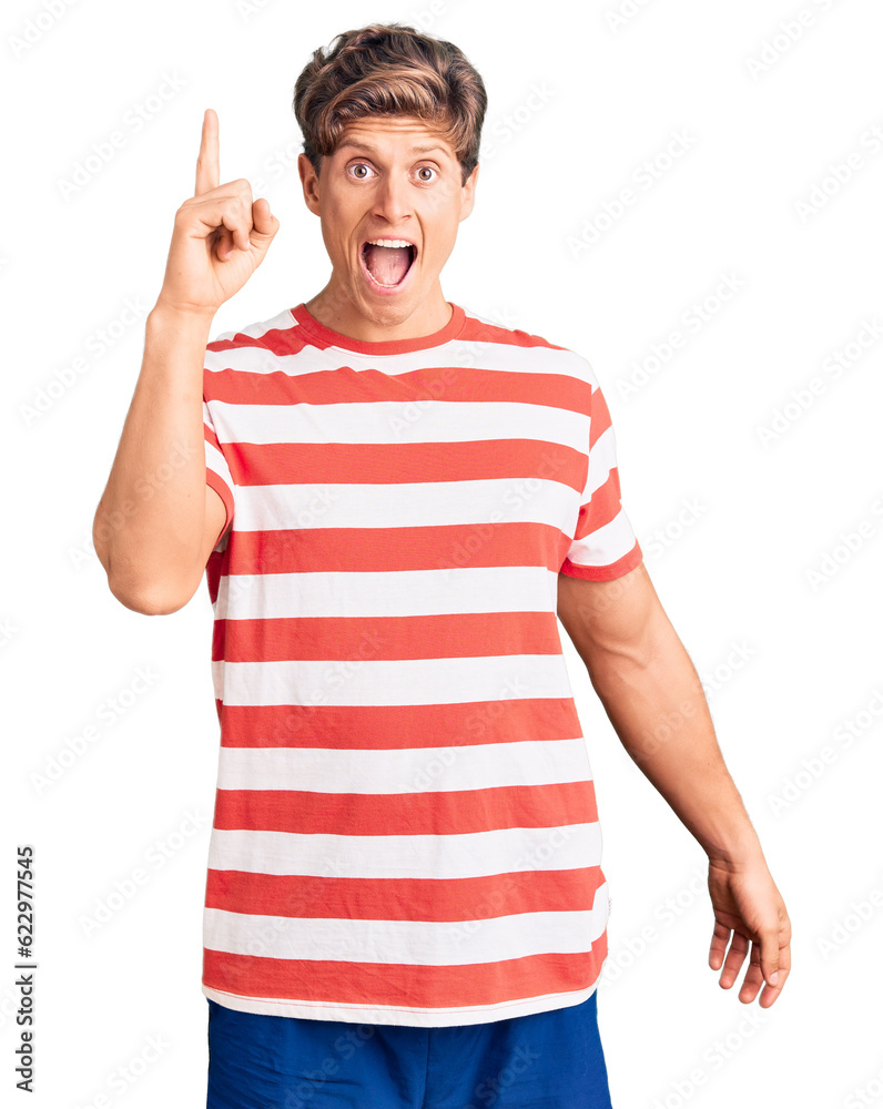 Young handsome man wearing casual clothes pointing finger up with successful idea. exited and happy. number one.