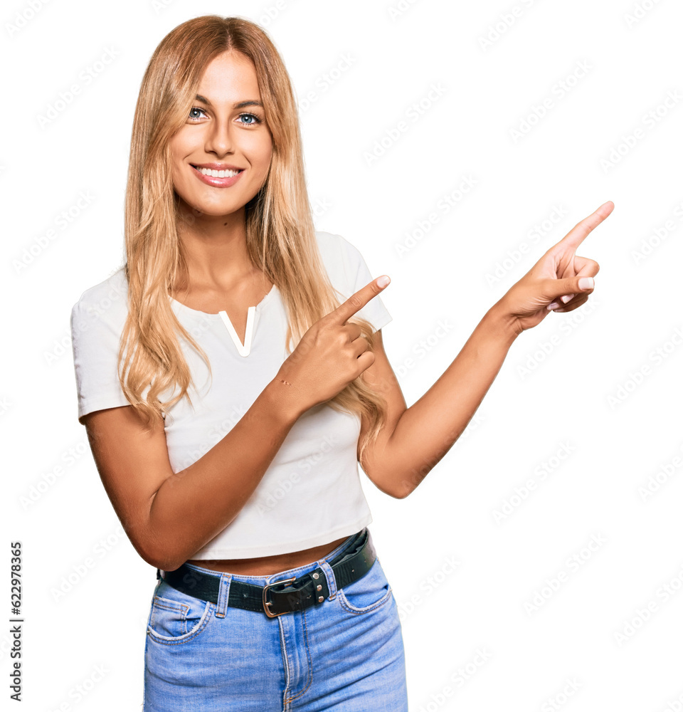 Beautiful blonde young woman wearing casual white tshirt smiling and looking at the camera pointing with two hands and fingers to the side. Beautiful blonde young woman wearing casual white tshirt smiling and looking at the camera pointing with two hands and fingers to the side.