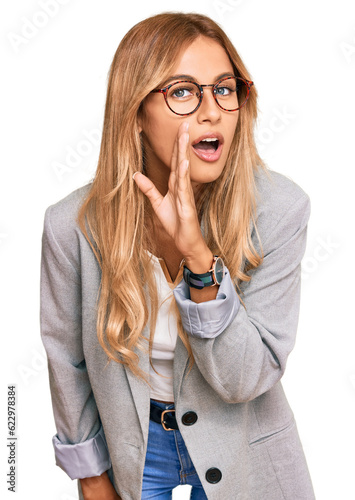 Obraz na płótnie Beautiful blonde young woman wearing business clothes hand on mouth telling secr