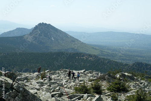 Panorama, landscape. In the foreground are rocks covered with moss, in the background are mountains. Summer, blue sky, day.