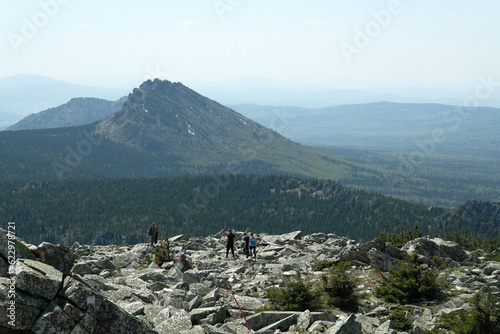 Panorama, landscape. In the foreground are rocks covered with moss, in the background are mountains. Summer, blue sky, day.