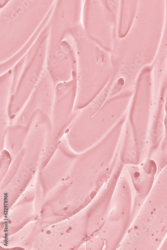 Transparent serum gel with hyaluronic acid for the face on a pink background. The texture of a cosmetic product with oxygen bubbles. Wellness and beauty concept.