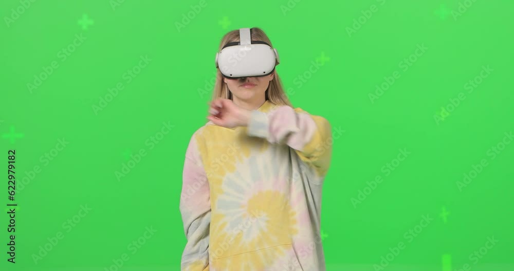 Horizontal shot on green screen background. VR or AR online at home. Cute girl clicks invisible buttons and pulls virtual sliders. Beautiful woman have fun at home. Virtual communication with friends. Horizontal shot on green screen background. VR or AR online at home. Cute girl clicks invisible buttons and pulls virtual sliders. Beautiful woman have fun at home. Virtual communication with friends.