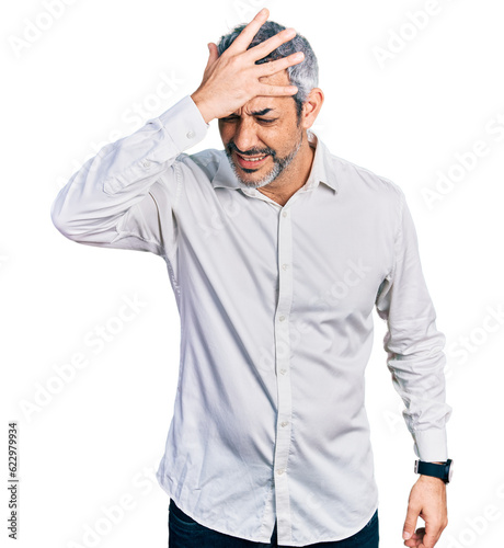 Middle age hispanic with grey hair wearing casual white shirt surprised with hand on head for mistake, remember error. forgot, bad memory concept. © Krakenimages.com