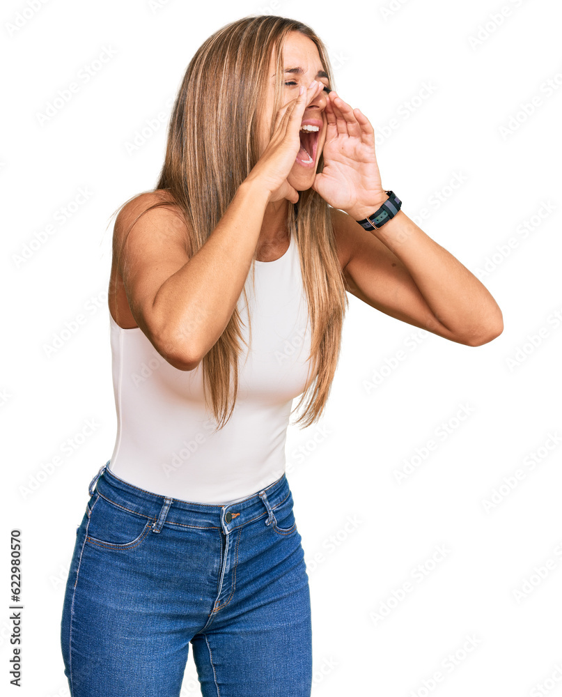 Young blonde woman wearing casual style with sleeveless shirt shouting angry out loud with hands over mouth Young blonde woman wearing casual style with sleeveless shirt shouting angry out loud with hands over mouth