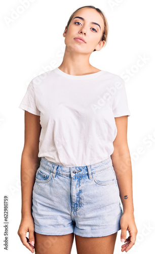 Young beautiful blonde woman wearing casual white tshirt relaxed with serious expression on face. simple and natural looking at the camera.