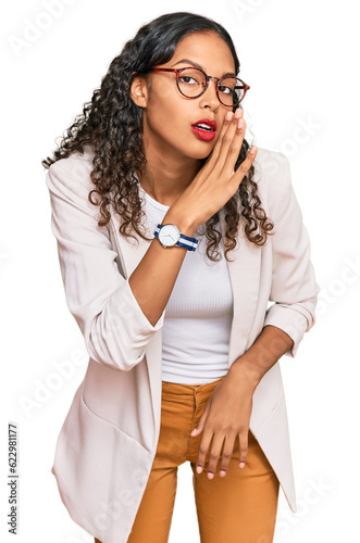 Young african american girl wearing business clothes hand on mouth telling secret rumor, whispering malicious talk conversation