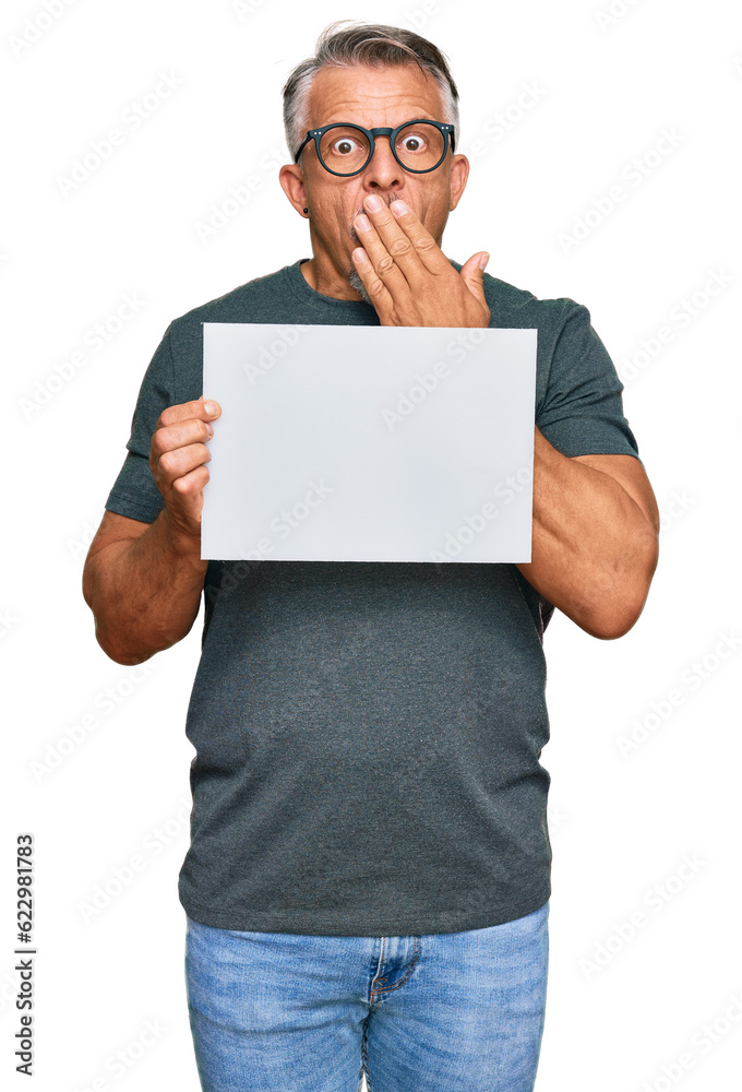 Middle age grey-haired man holding blank empty banner covering mouth with hand, shocked and afraid for mistake. surprised expression Middle age grey-haired man holding blank empty banner covering mouth with hand, shocked and afraid for mistake. surprised expression