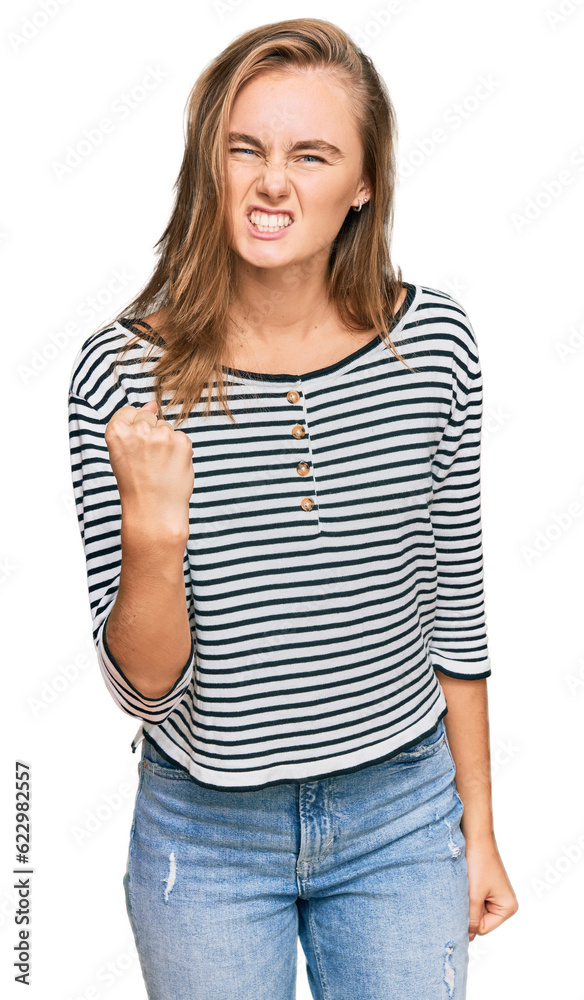 Beautiful blonde woman wearing casual clothes angry and mad raising fist frustrated and furious while shouting with anger. rage and aggressive concept. Beautiful blonde woman wearing casual clothes angry and mad raising fist frustrated and furious while shouting with anger. rage and aggressive concept.