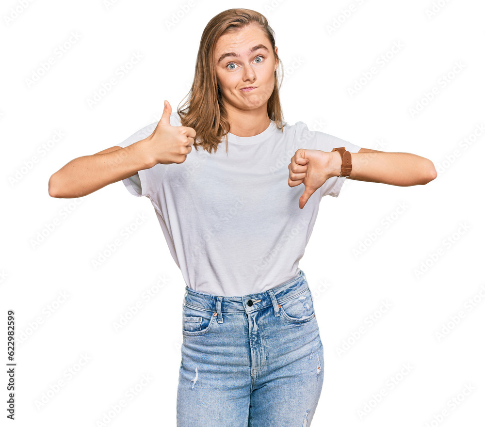 Beautiful young blonde woman wearing casual white t shirt doing thumbs up and down, disagreement and agreement expression. crazy conflict Beautiful young blonde woman wearing casual white t shirt doing thumbs up and down, disagreement and agreement expression. crazy conflict