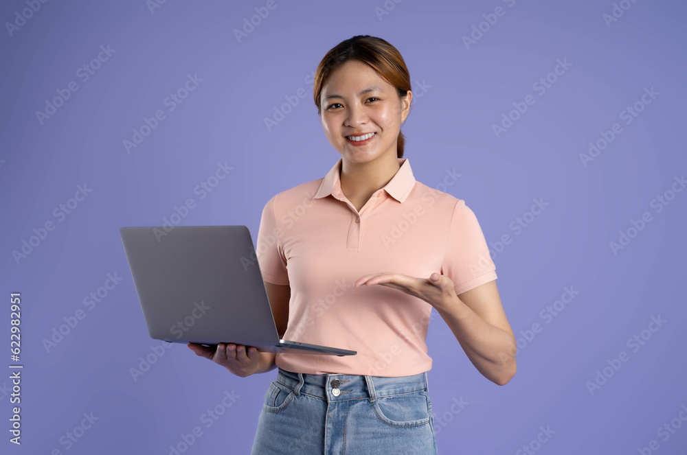 image of young asian girl using laptop on purple background image of young asian girl using laptop on purple background