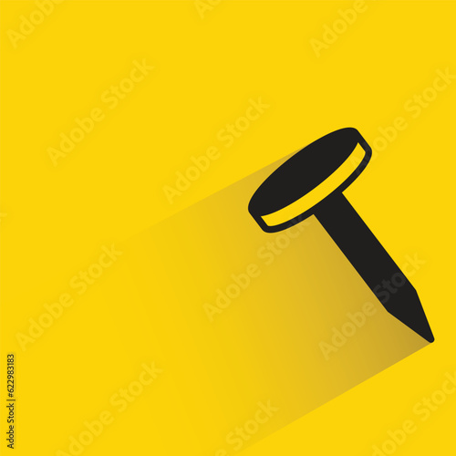 tack with shadow on yellow background
