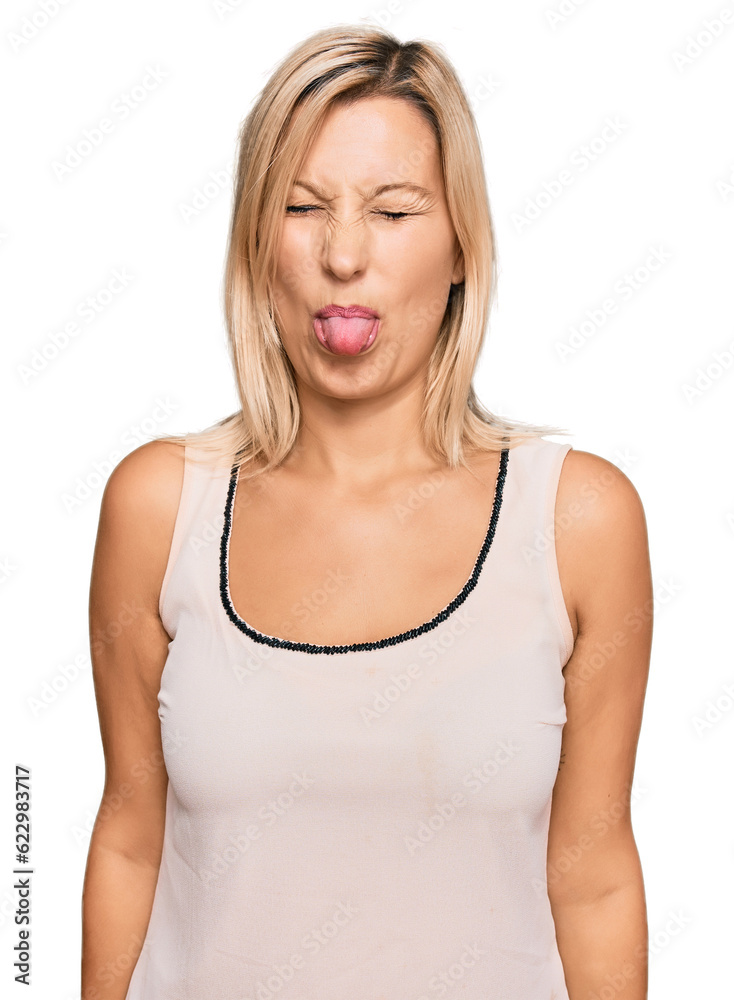 Middle age caucasian woman wearing casual clothes sticking tongue out happy with funny expression. emotion concept. Middle age caucasian woman wearing casual clothes sticking tongue out happy with funny expression. emotion concept.