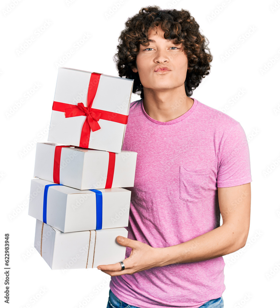 Caucasian teenager holding gifts looking at the camera blowing a kiss being lovely and sexy. love expression. Caucasian teenager holding gifts looking at the camera blowing a kiss being lovely and sexy. love expression.