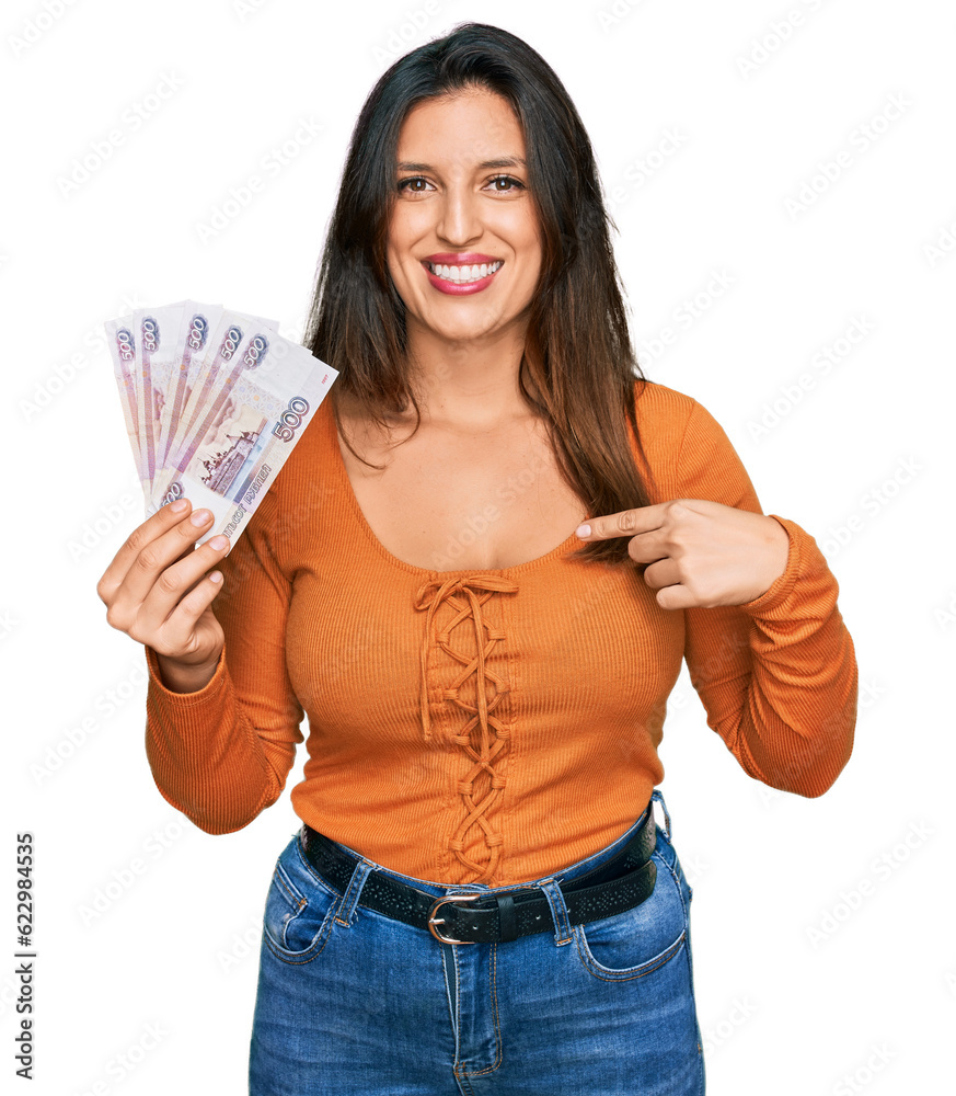 Beautiful hispanic woman holding russian 500 ruble banknotes pointing finger to one self smiling happy and proud Beautiful hispanic woman holding russian 500 ruble banknotes pointing finger to one self smiling happy and proud
