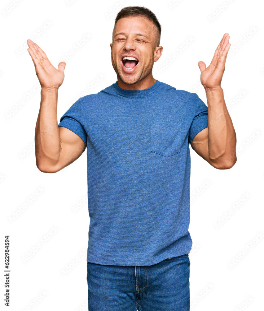 Handsome muscle man wearing casual clothes celebrating mad and crazy for success with arms raised and closed eyes screaming excited. winner concept Handsome muscle man wearing casual clothes celebrating mad and crazy for success with arms raised and closed eyes screaming excited. winner concept