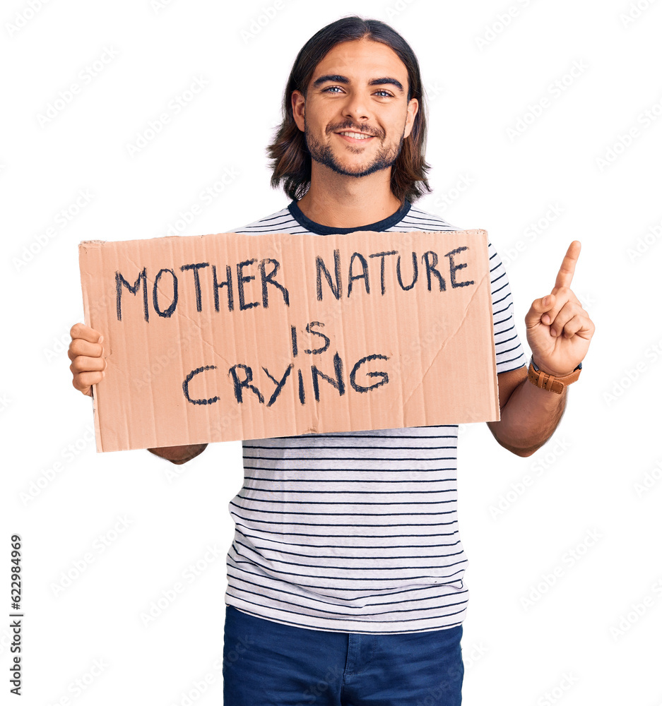 Young handsome man holding mother nature is crying protest cardboard banner surprised with an idea or question pointing finger with happy face, number one Young handsome man holding mother nature is crying protest cardboard banner surprised with an idea or question pointing finger with happy face, number one