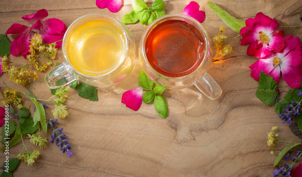 herbal tea in glass cups with flowers and herbs on wooden background herbal tea in glass cups with flowers and herbs on wooden background