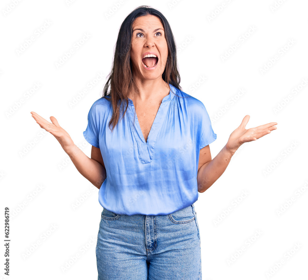 Young beautiful brunette woman wearing casual t-shirt crazy and mad shouting and yelling with aggressive expression and arms raised. frustration concept. Young beautiful brunette woman wearing casual t-shirt crazy and mad shouting and yelling with aggressive expression and arms raised. frustration concept.