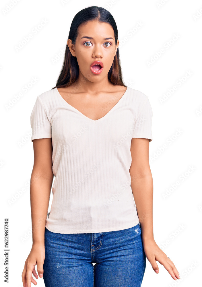 Obraz premium Young beautiful latin girl wearing casual white t shirt scared and amazed with open mouth for surprise, disbelief face