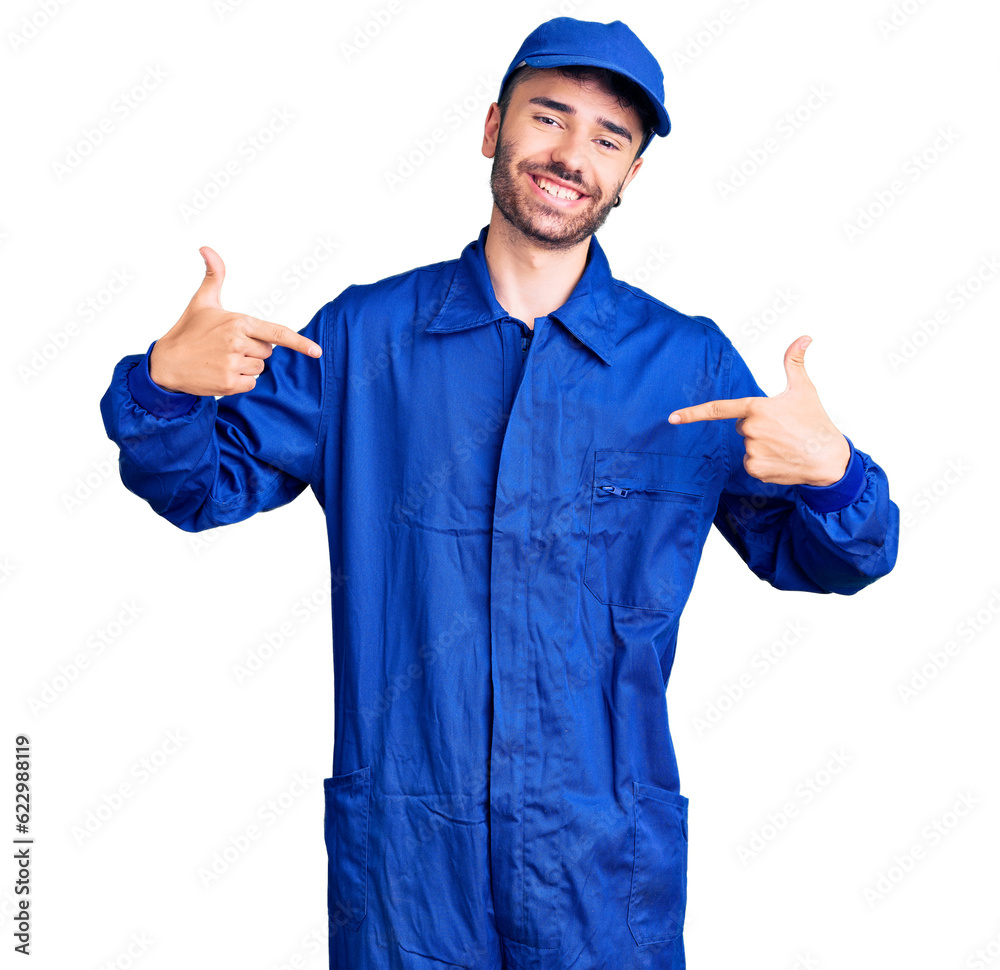 Young hispanic man wearing painter uniform looking confident with smile on face, pointing oneself with fingers proud and happy. Young hispanic man wearing painter uniform looking confident with smile on face, pointing oneself with fingers proud and happy.