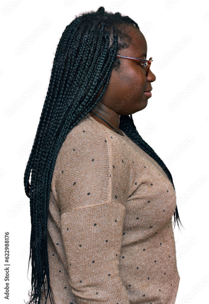 Fototapeta premium Young black woman with braids wearing casual clothes and glasses looking to side, relax profile pose with natural face with confident smile.