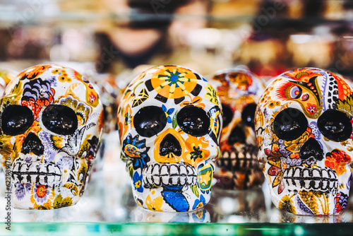 Εκτύπωση καμβά Crâne tête de mort mexicain colorés posés sur une étagère, objets de décoration