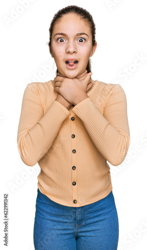 Beautiful brunette little girl wearing casual sweater shouting and suffocate because painful strangle. health problem. asphyxiate and suicide concept.