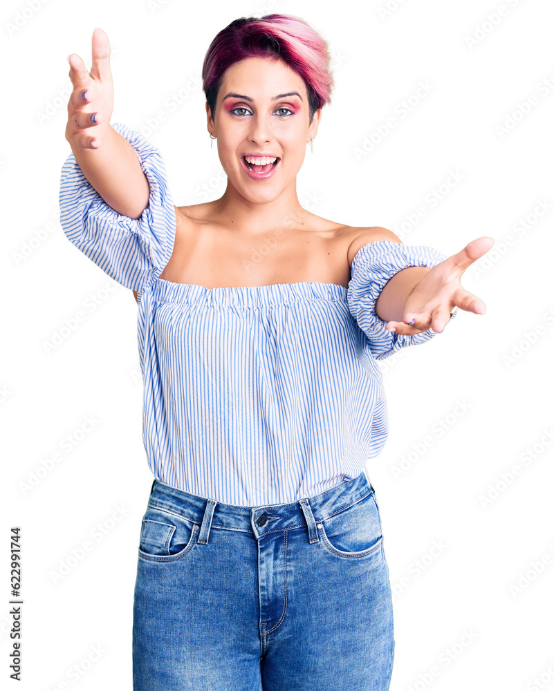 Young beautiful woman with pink hair wearing casual clothes looking at the camera smiling with open arms for hug. cheerful expression embracing happiness. Young beautiful woman with pink hair wearing casual clothes looking at the camera smiling with open arms for hug. cheerful expression embracing happiness.