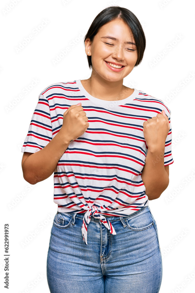 Beautiful young woman with short hair wearing casual clothes excited for success with arms raised and eyes closed celebrating victory smiling. winner concept.
