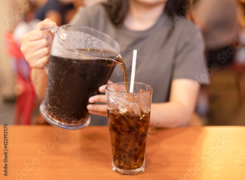 Quadro su tela Woman pouring soft drink into glass in the restaurant