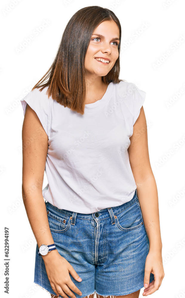 Young caucasian woman wearing casual white tshirt looking away to side with smile on face, natural expression. laughing confident. Young caucasian woman wearing casual white tshirt looking away to side with smile on face, natural expression. laughing confident.