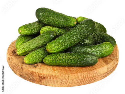 Fresh cucumbers on round wooden board  transparent background