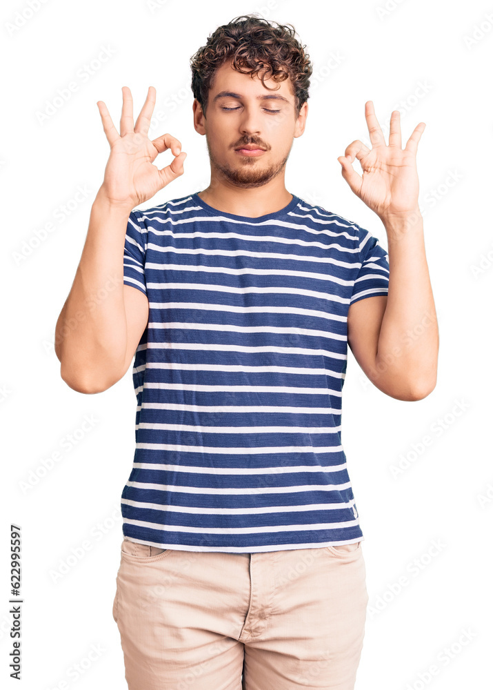 Young handsome man with curly hair wearing casual clothes relax and smiling with eyes closed doing meditation gesture with fingers. yoga concept. Young handsome man with curly hair wearing casual clothes relax and smiling with eyes closed doing meditation gesture with fingers. yoga concept.
