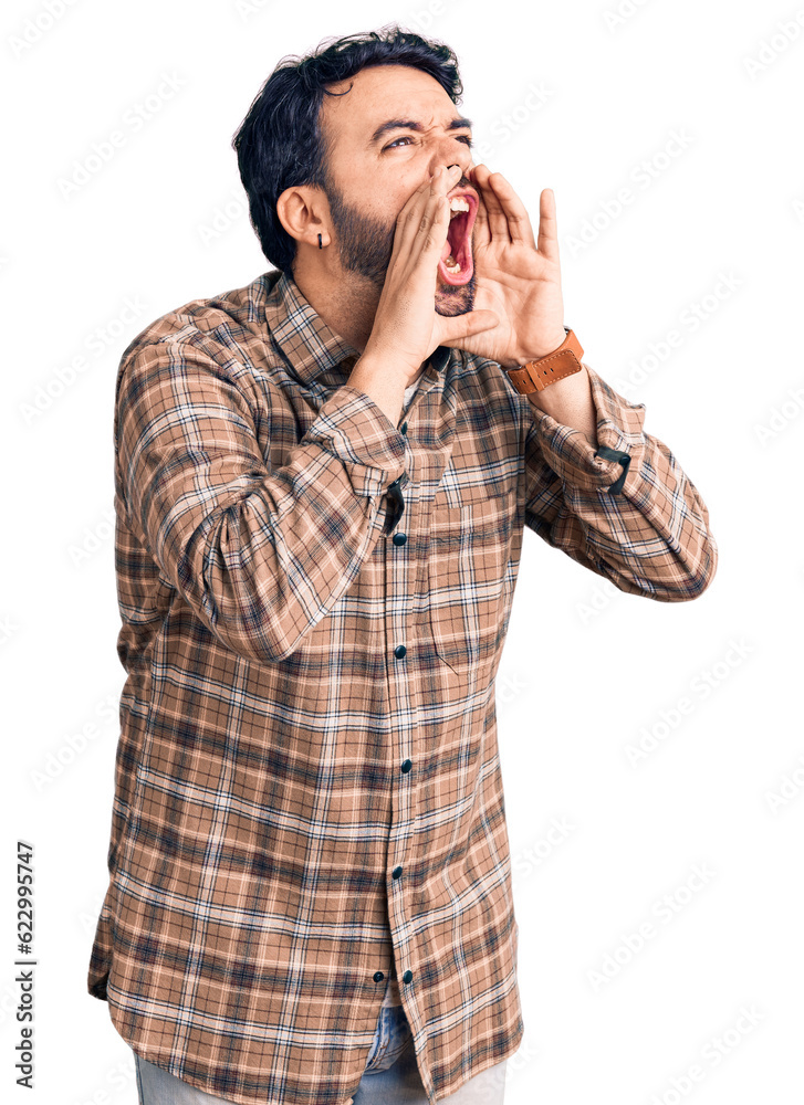 Young hispanic man wearing casual clothes shouting angry out loud with hands over mouth Young hispanic man wearing casual clothes shouting angry out loud with hands over mouth