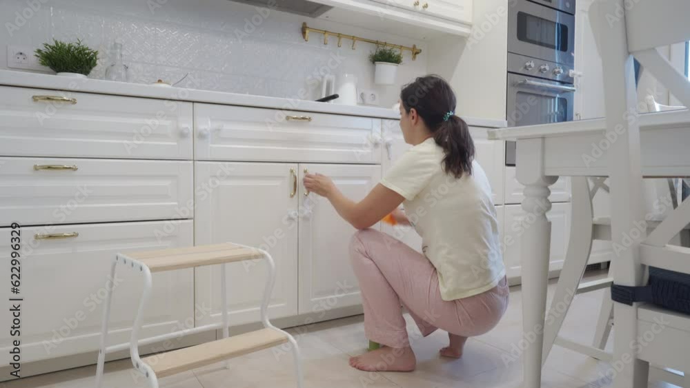 woman cleaning white kitchen at home woman cleaning white kitchen at home
