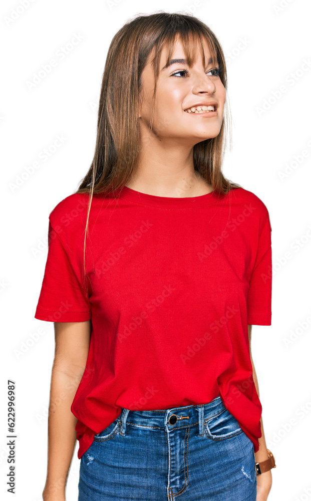 Teenager caucasian girl wearing casual red t shirt looking away to side with smile on face, natural expression. laughing confident. Teenager caucasian girl wearing casual red t shirt looking away to side with smile on face, natural expression. laughing confident.